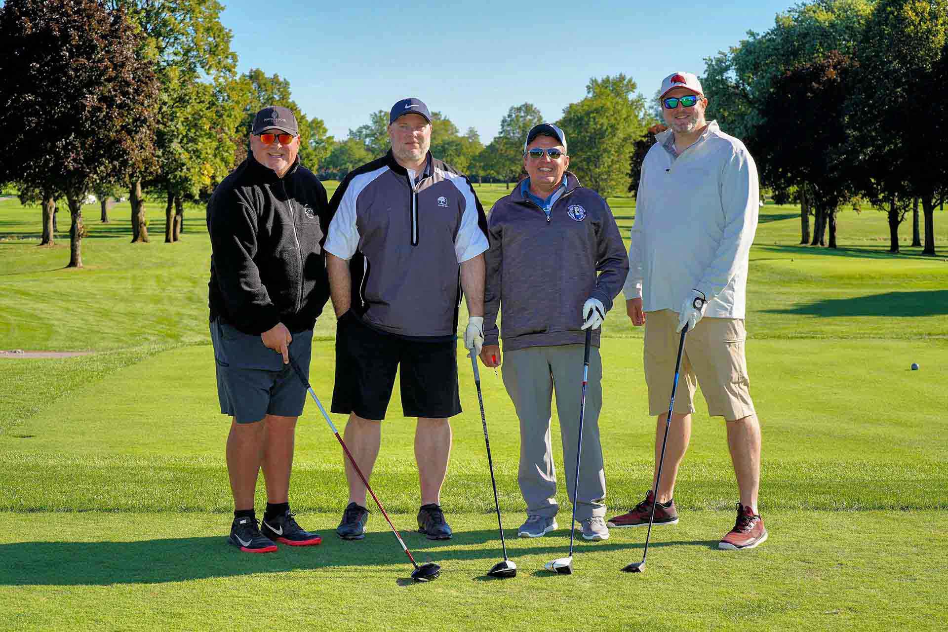 2020-endownment-classic-four-golfers-smiling-on-golf-course-holding-golf-clubs