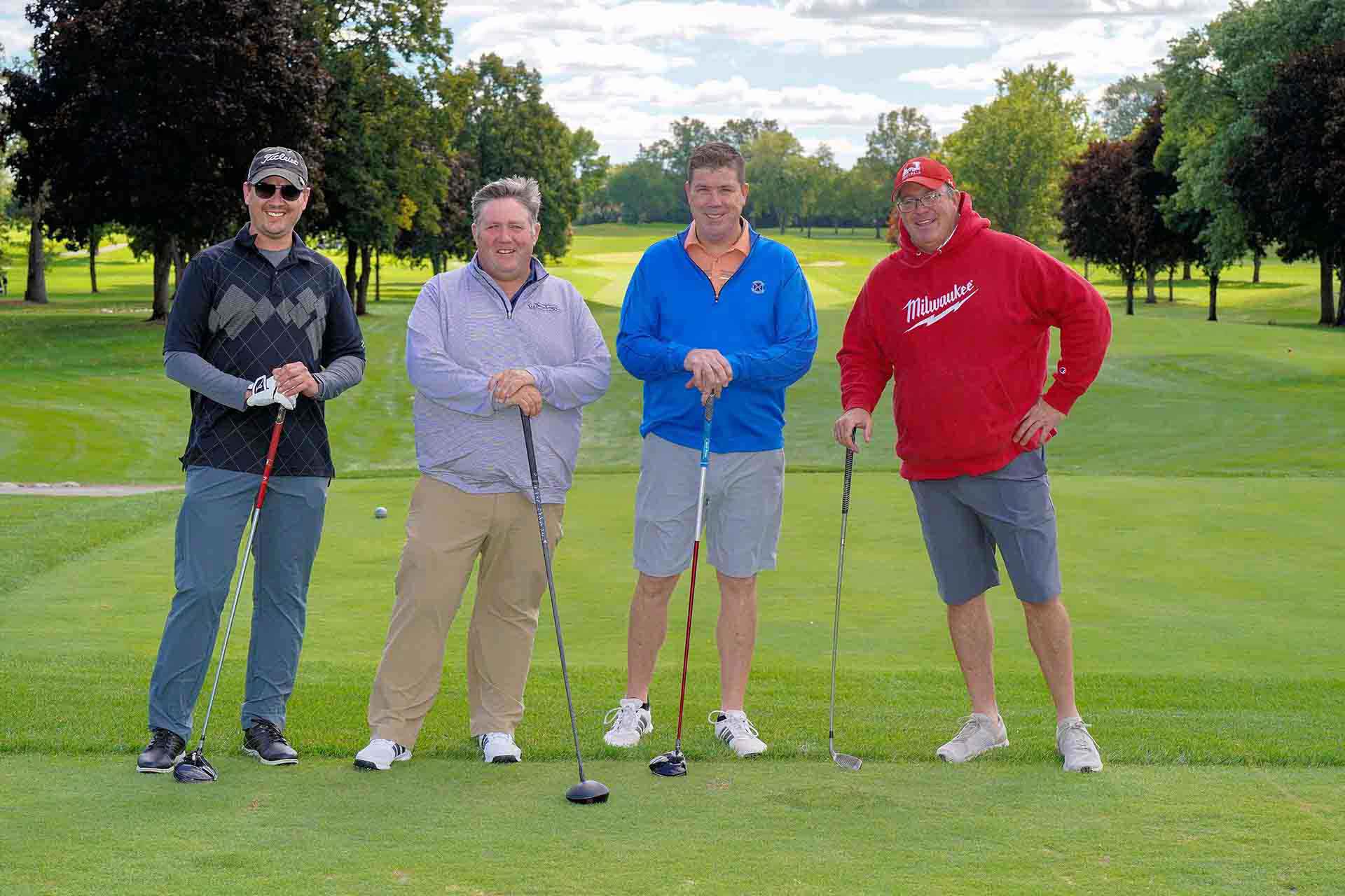 2020-endownment-classic-four-people-pose-for-photo-holding-golf-clubs