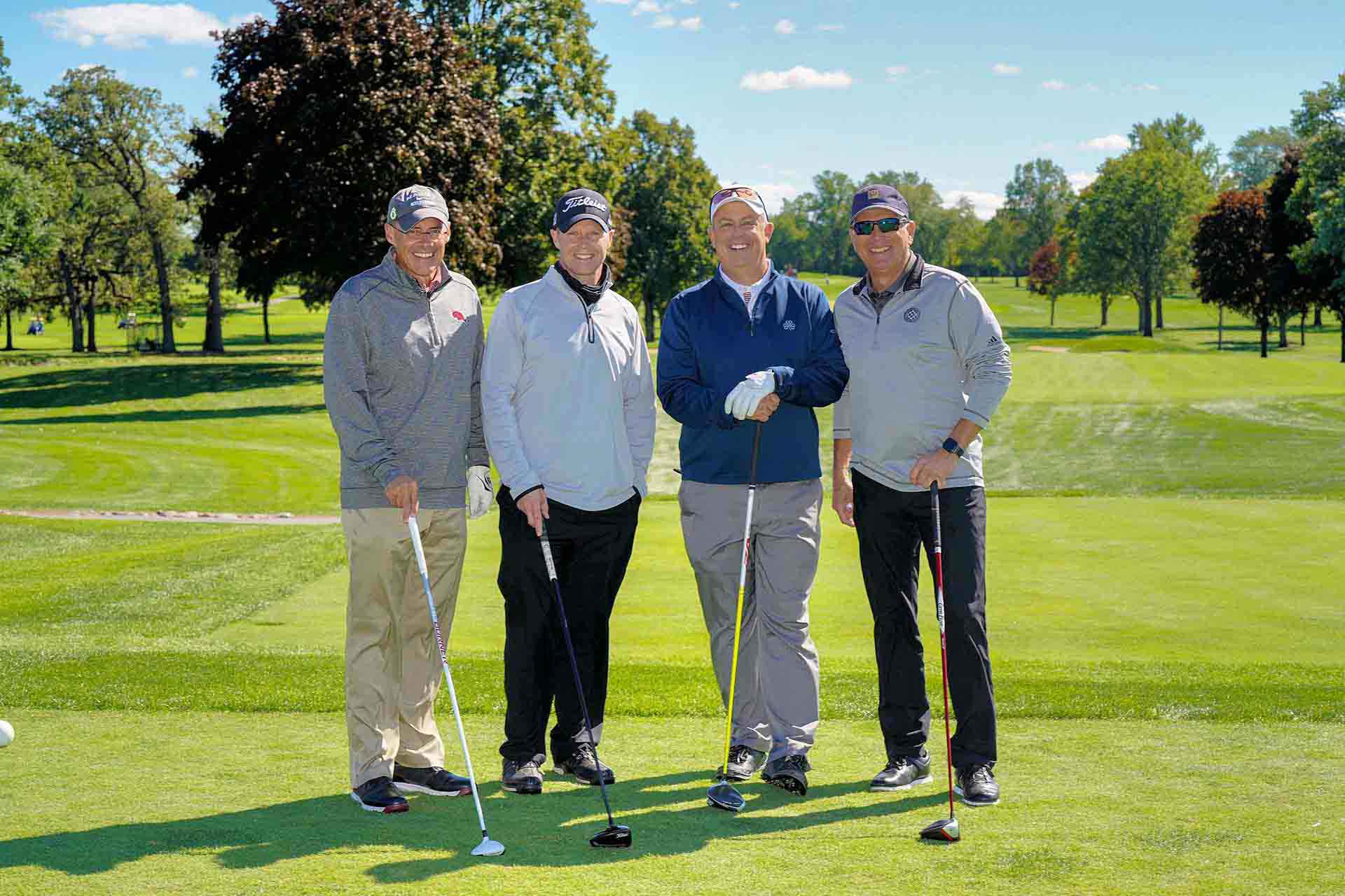 2020-endownment-classic-four-people-smiling-on-golf-course-at-event