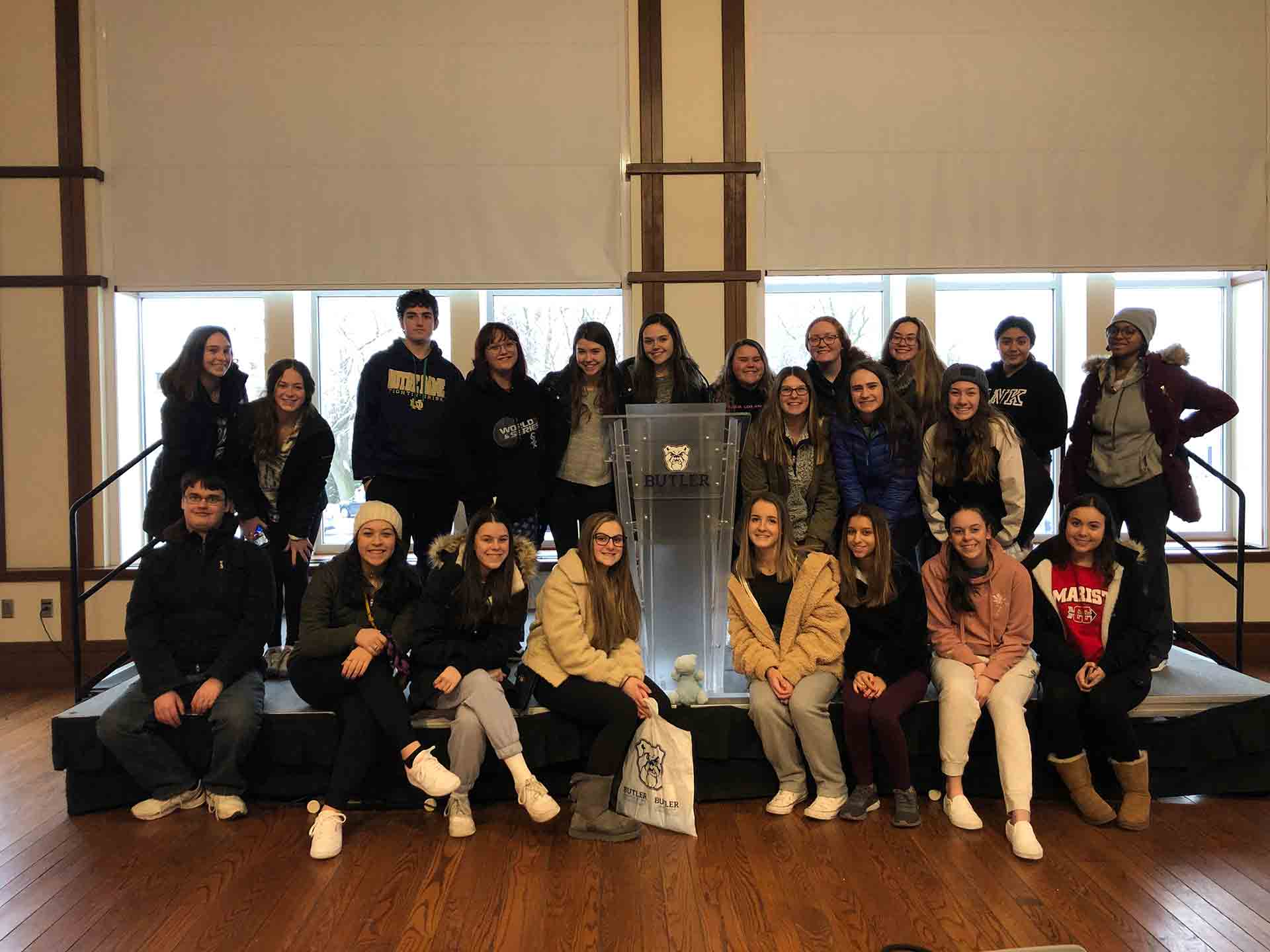2020-explore-college-tour-student-group-photo-with-butler-podium