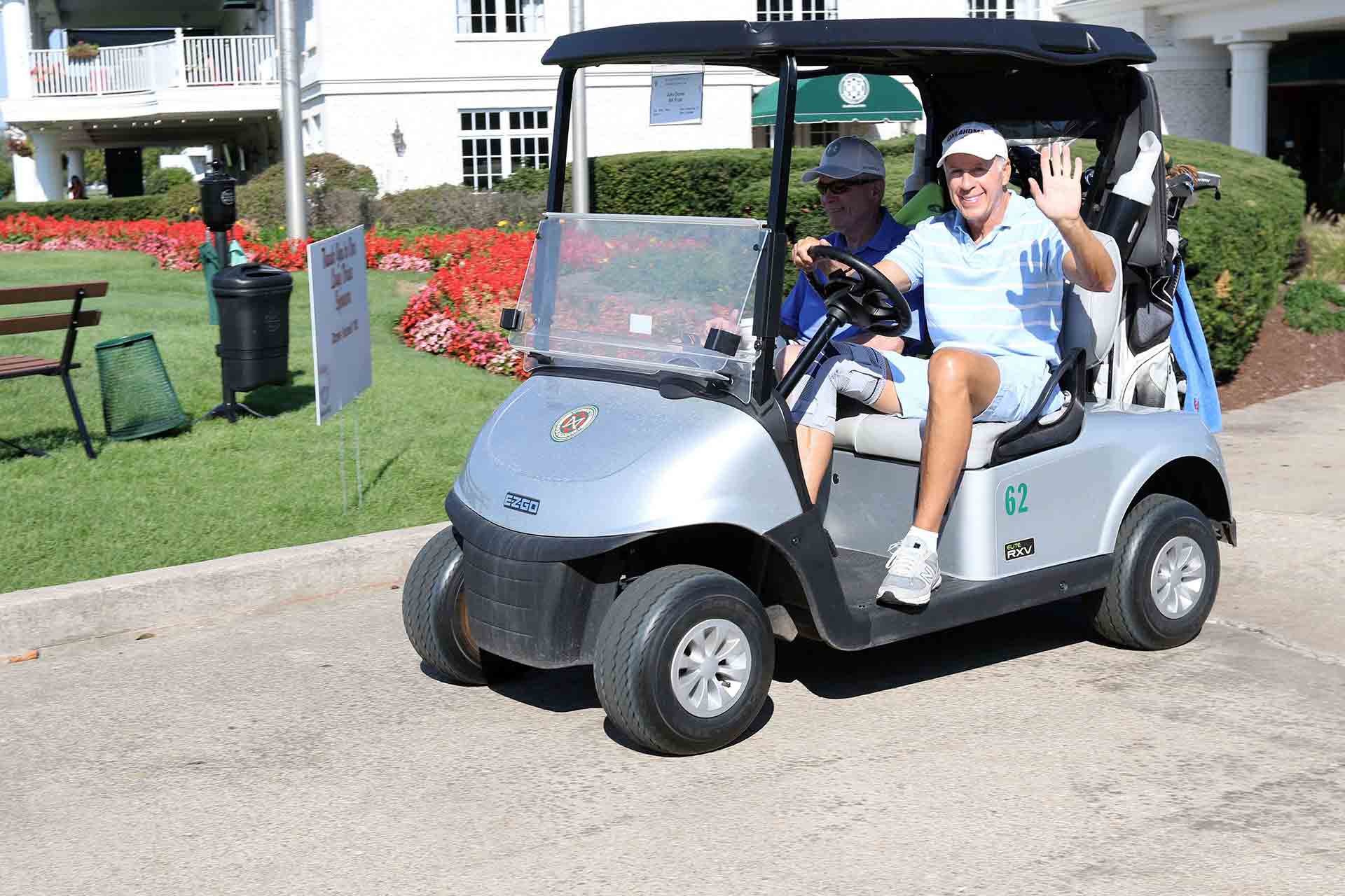 2021-endowment-classic-person-driving-golf-cart-waving