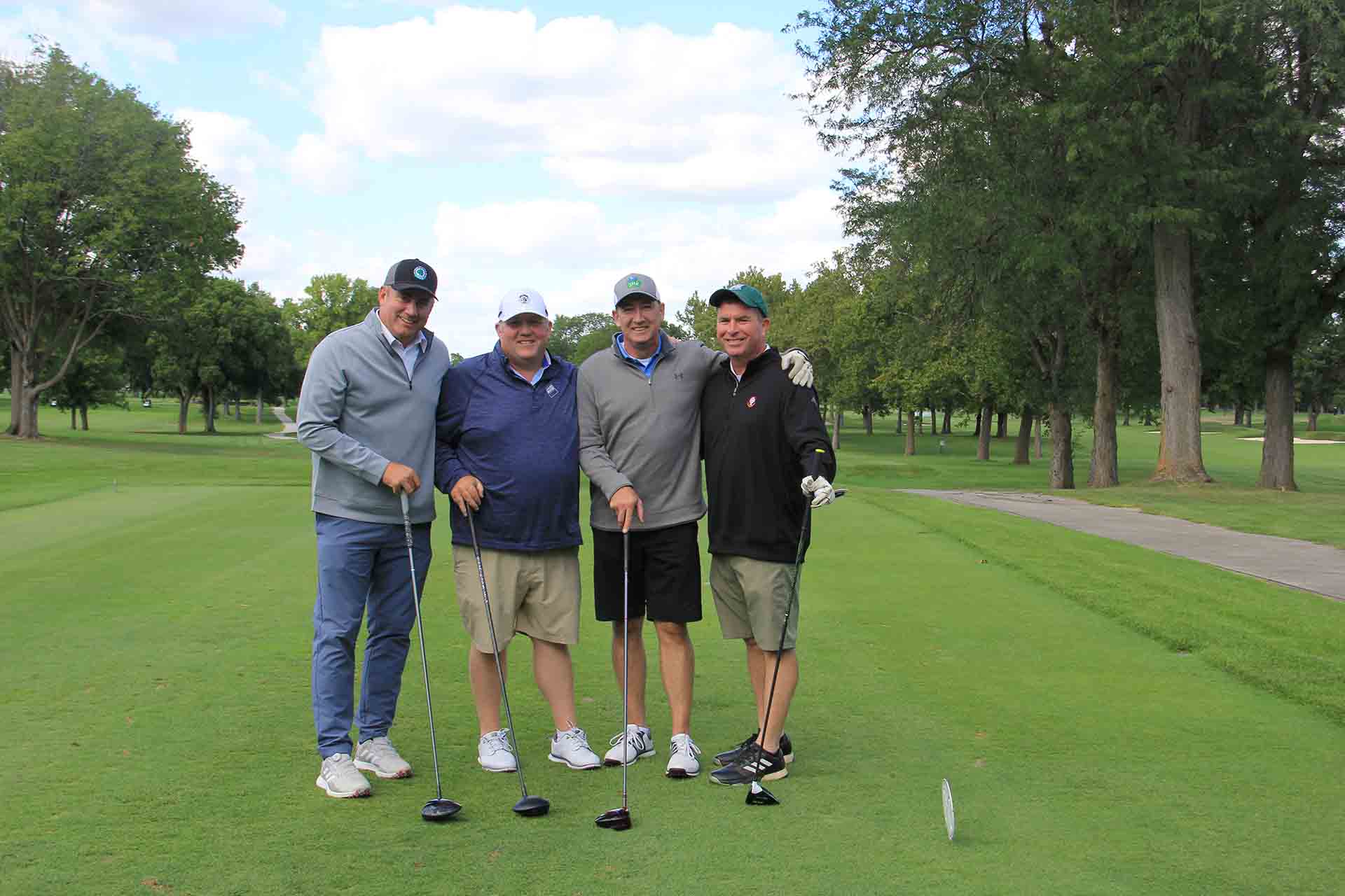 2022-Endowment-Golf-Classic-four-people-pose-on-golf-course-smiling