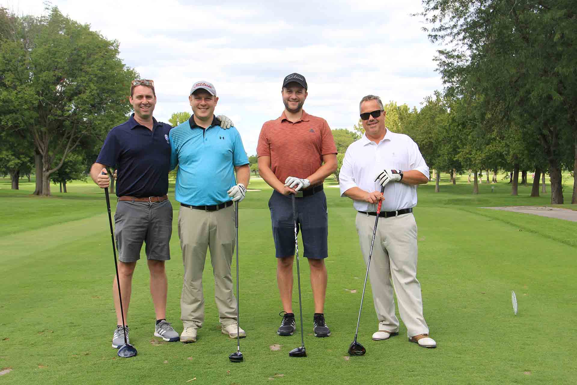2022-Endowment-Golf-Classic-four-people-pose-on-green-golf-course