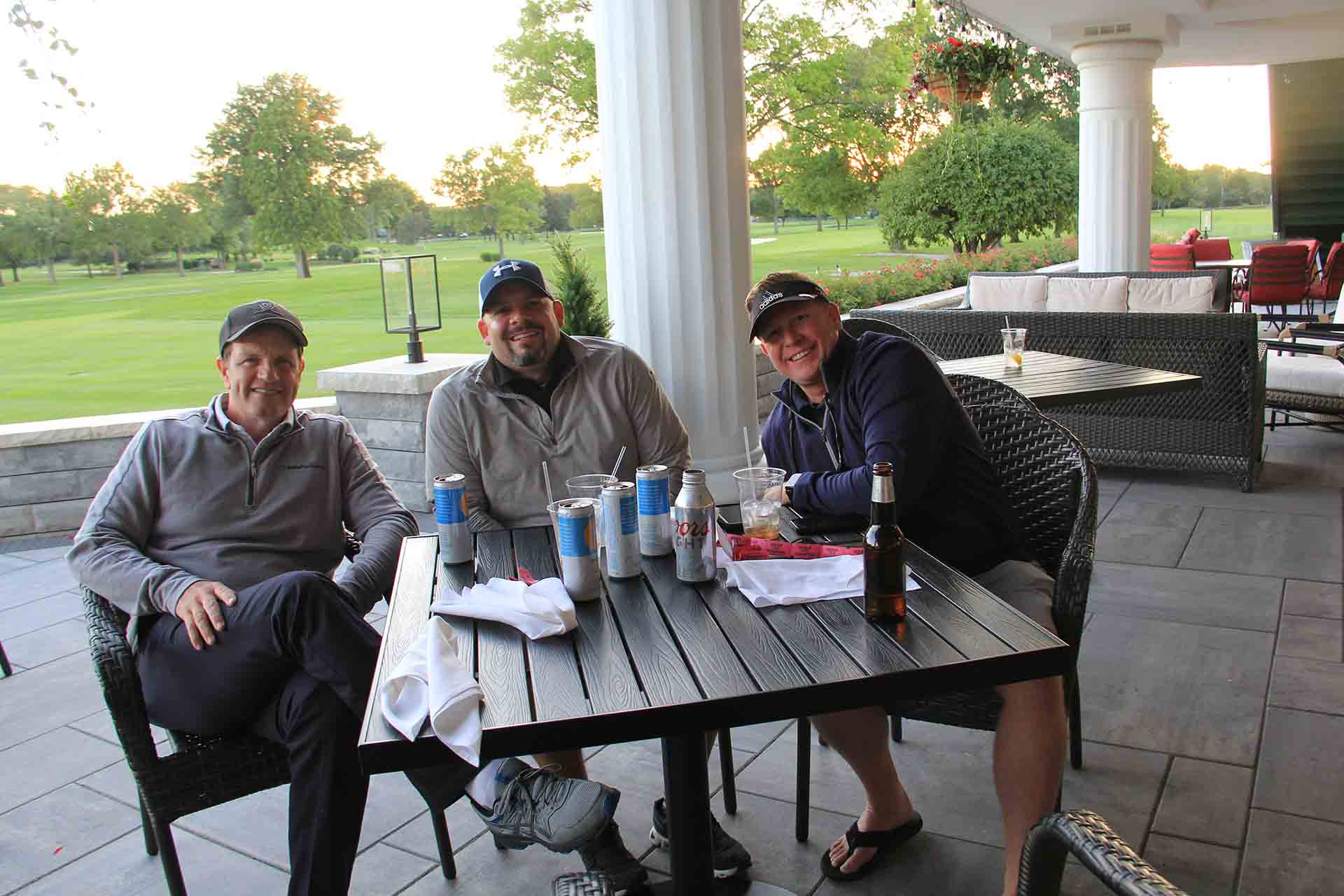 2022-Endowment-Golf-Classic-three-people-smile-while-sitting-for-a-group-photo