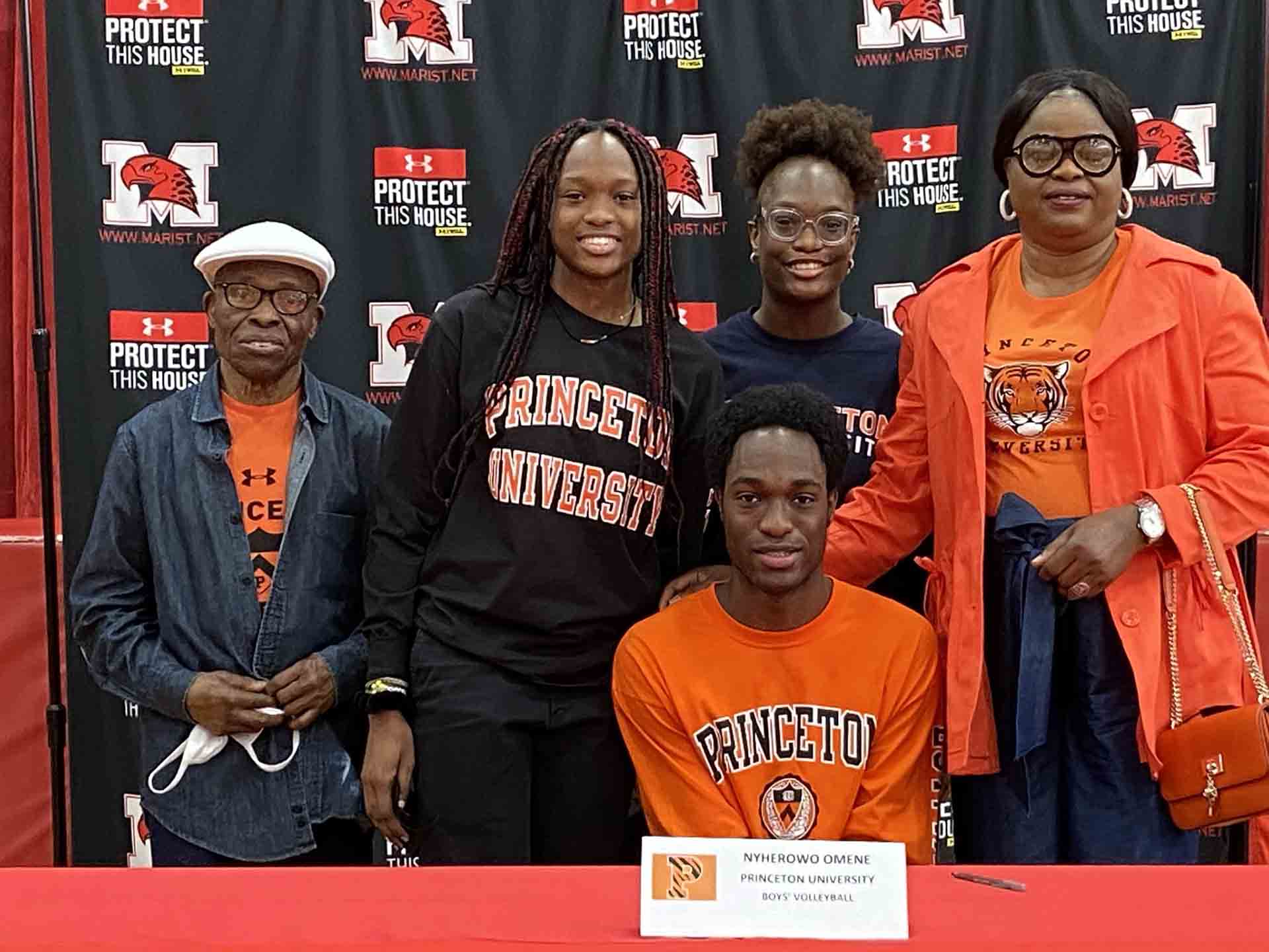 NLI-April-2021-person-smiles-while-signing-to-princeton-with-family