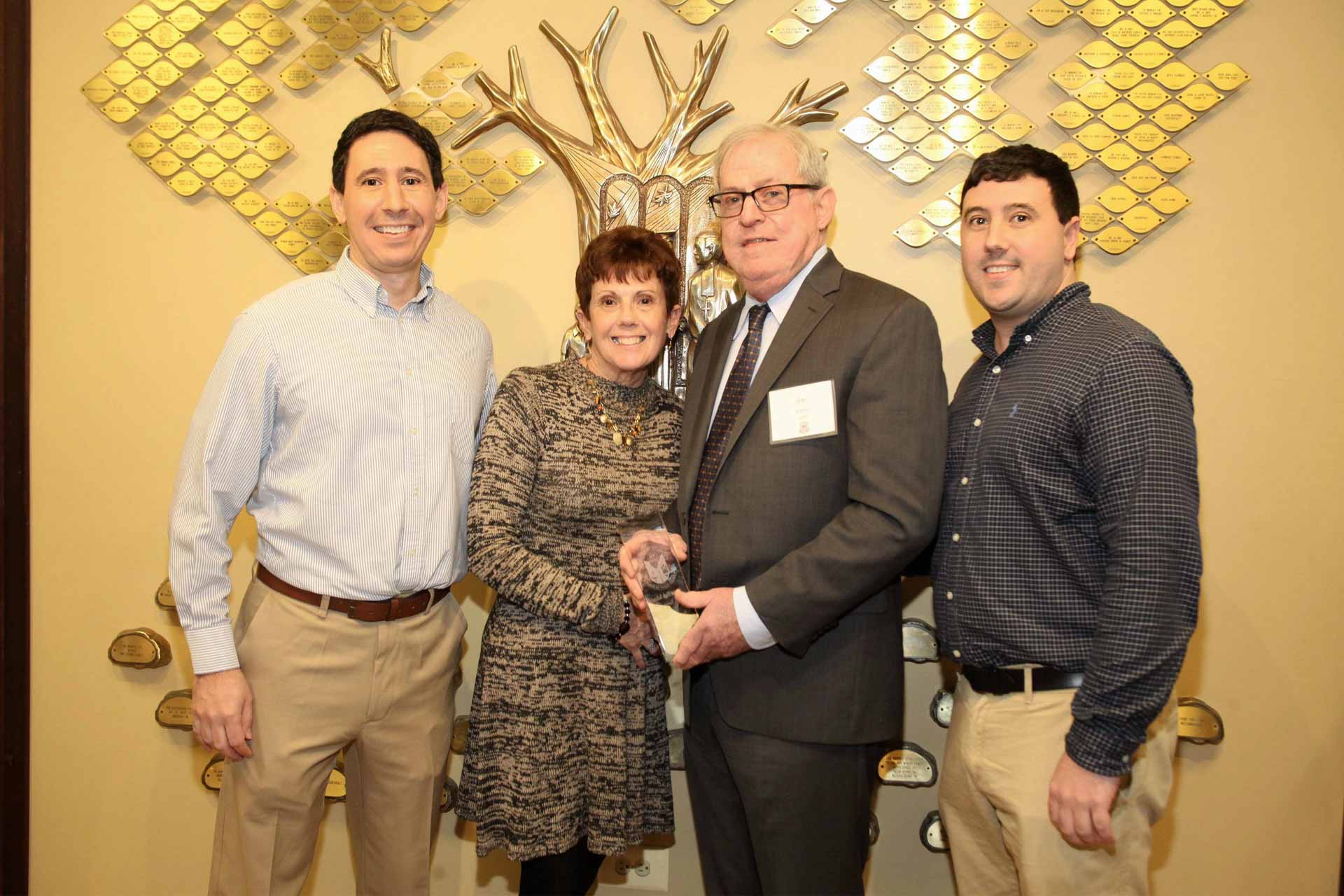 alumni-renion-and-awards-night-2020-family-in-front-of-school-tree