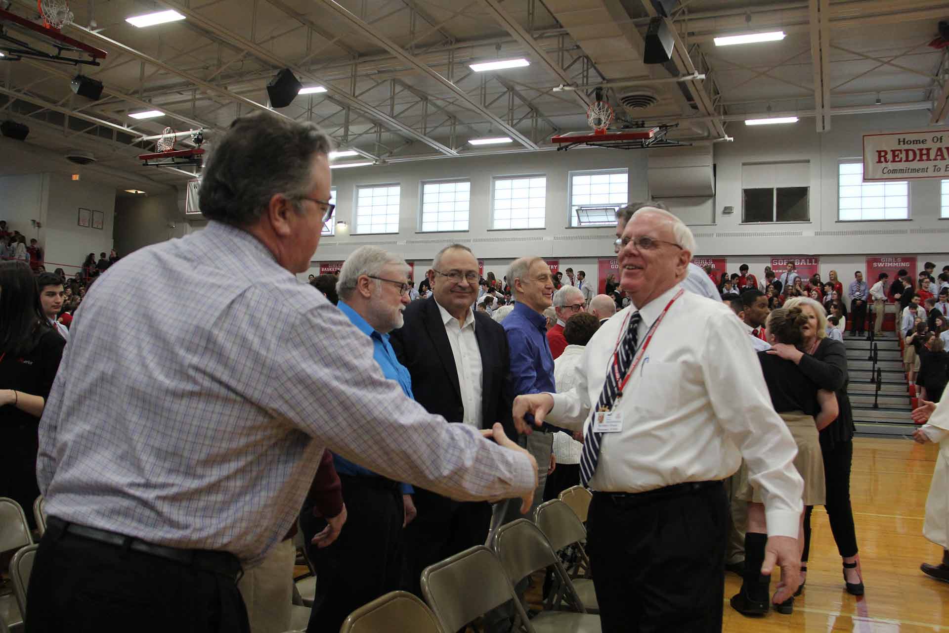 catholic-schools-week-mass-2020-man-reaching-out-to-shake-hands