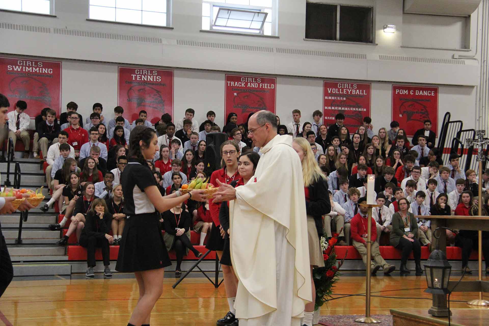 catholic-schools-week-mass-2020-student-handing-fruit-to-priest
