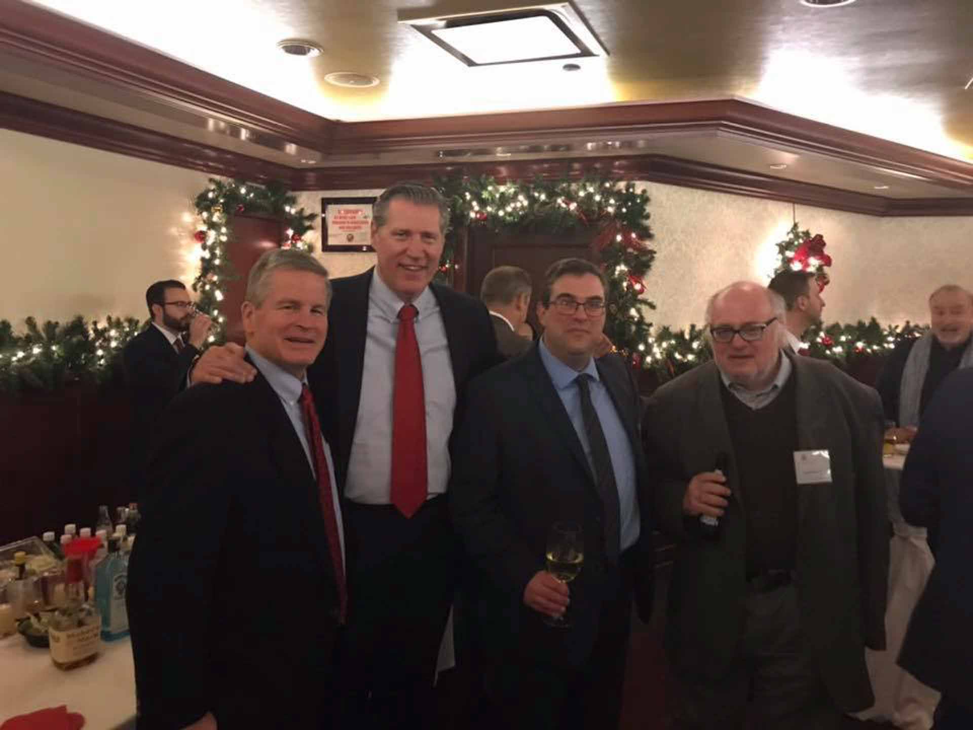 law-association-christmas-social-2019-three-people-and-the-school-president-smile-for-photo