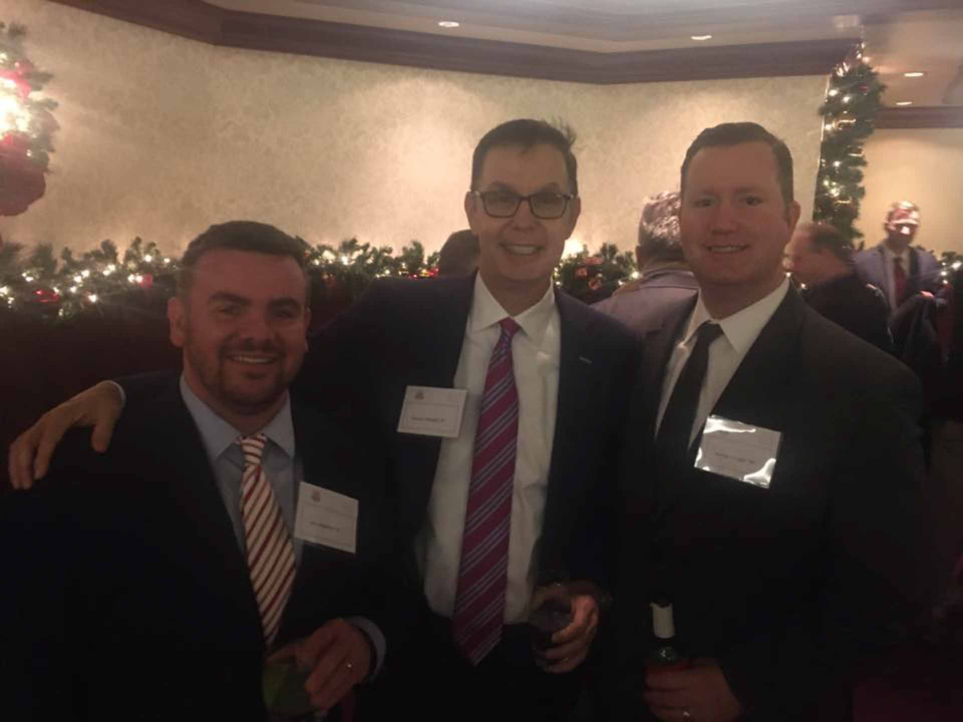 law-association-christmas-social-2019-three-people-smile-at-event