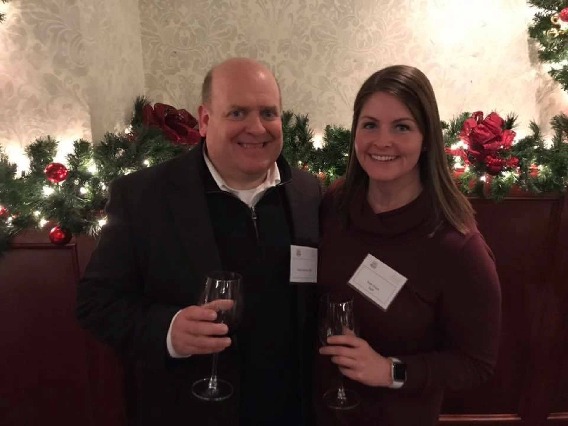law-association-christmas-social-2019-two-people-smile-while-holding-drinks