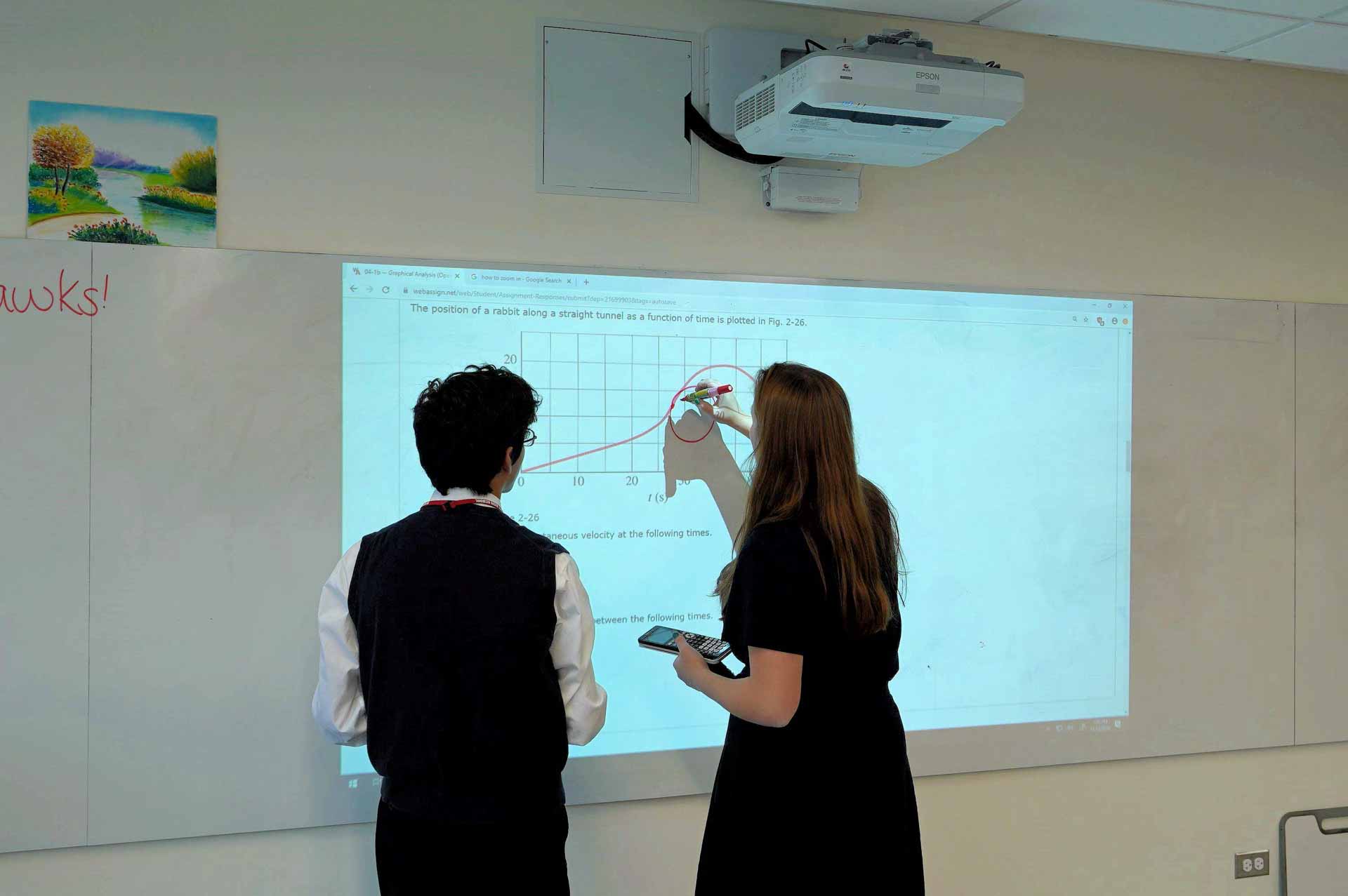 monastery-hall-dedication-teacher-and-student-at-white-board-with-projector-own