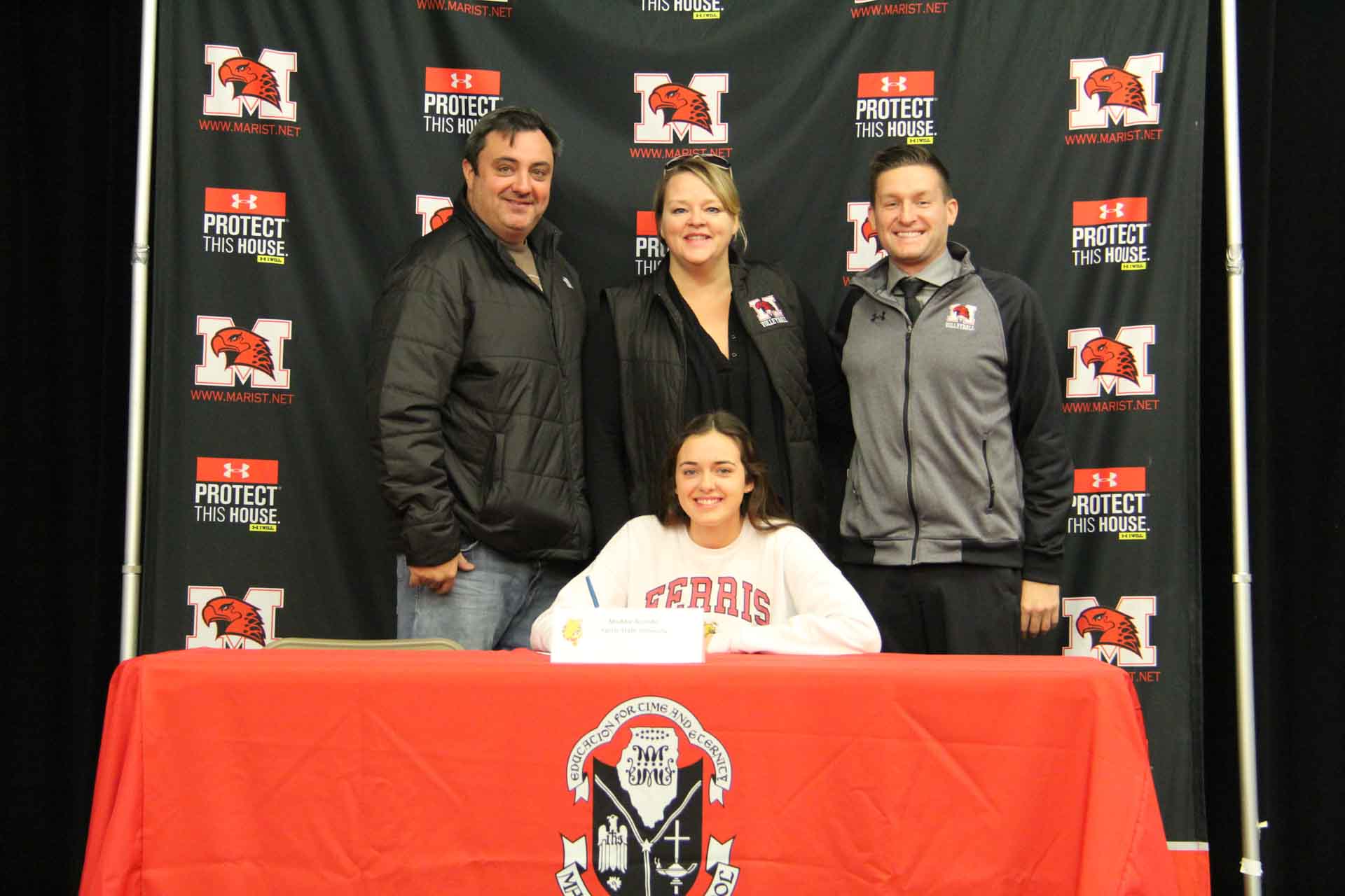 nli-signing-november-2019-person-with-parents-and-faculty-smiling-at-college-signing