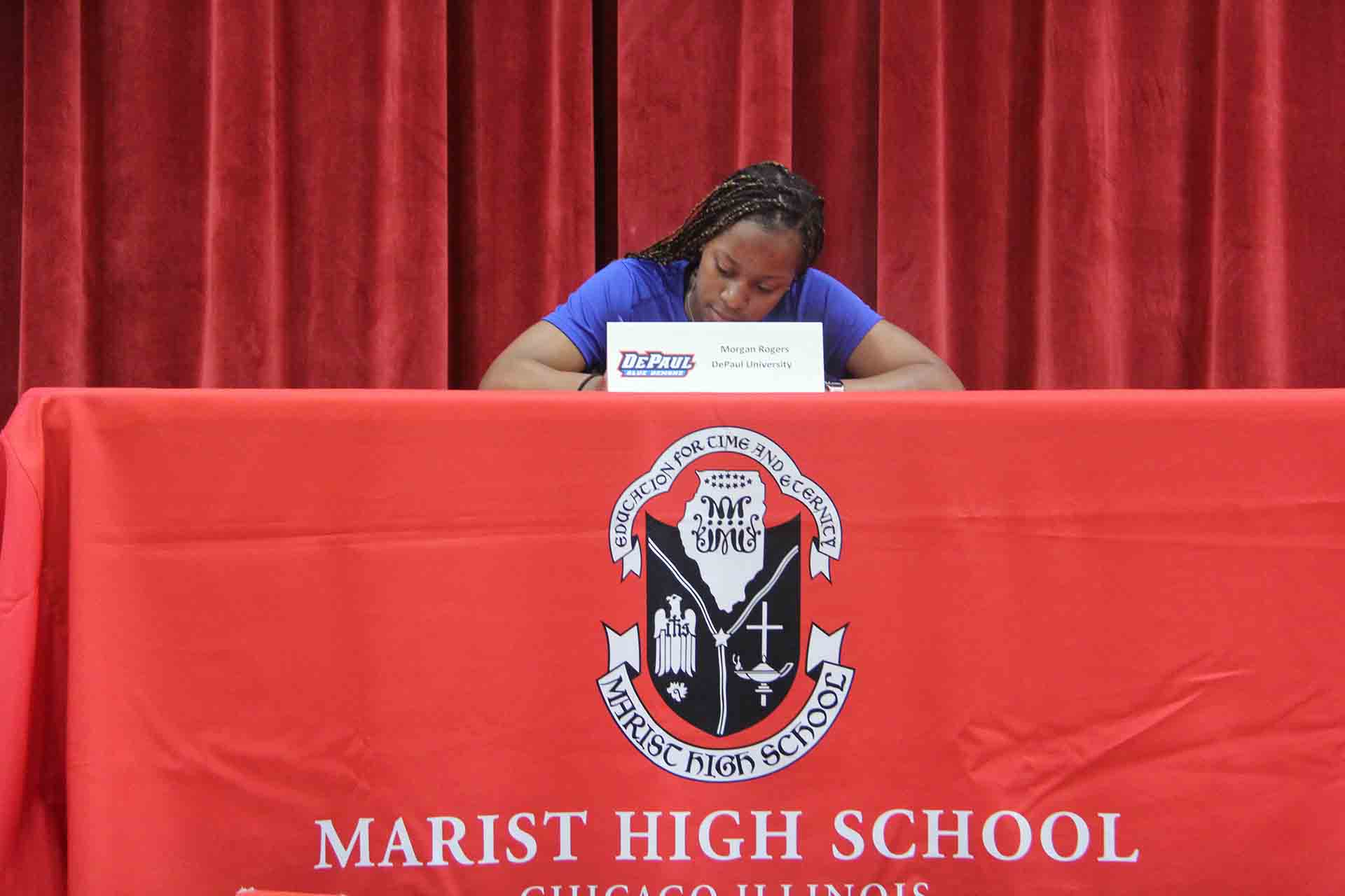 student-looks-down-while-signing-to-depaul-university