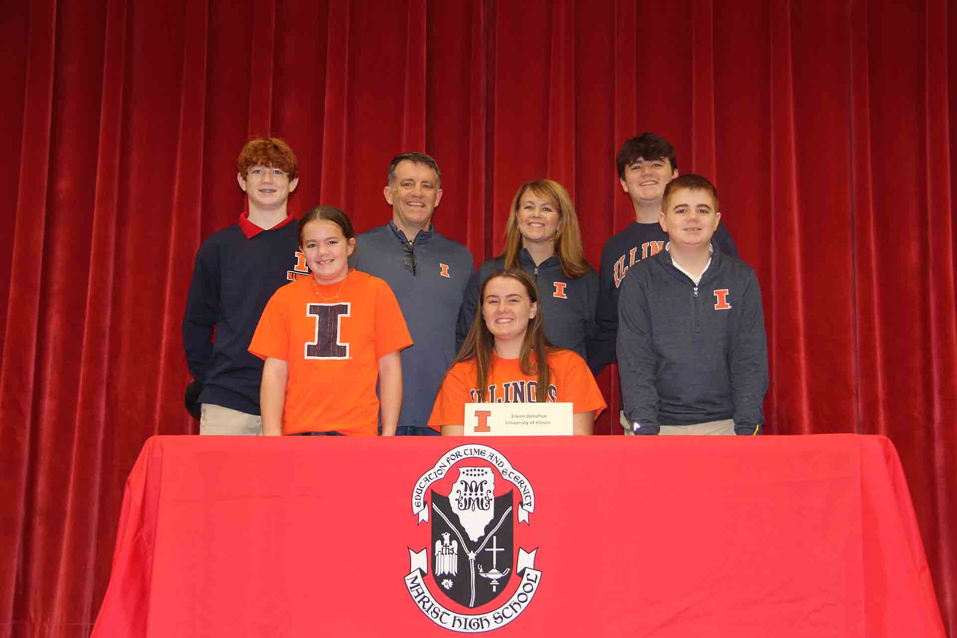 student-wears-university-of-illinois-merch-with-family-at-signing